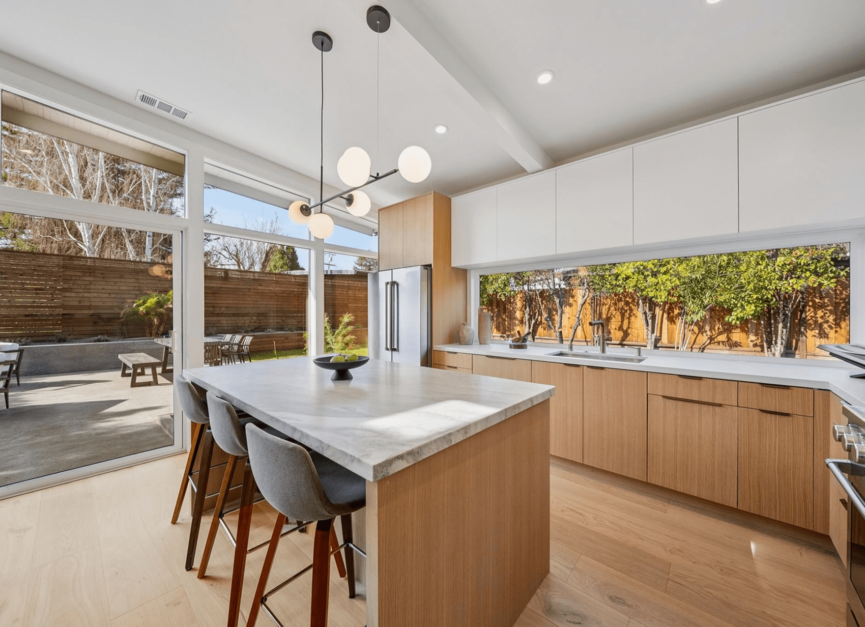 Modern kitchen with island and large windows.